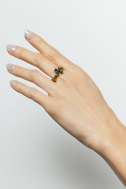 Bague la veine noir bingo club à la main d'une femme motif trèfle en émail noir, finition dorée à l'or fin, taille ajustable, résistante au quotidien. Design exclusif Bingo Club.