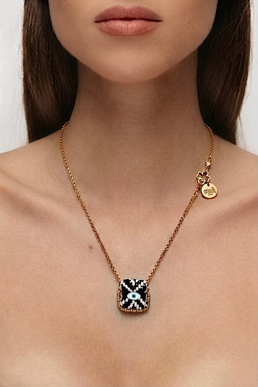 Collier œil porte-bonheur Bingo Ojo Black Magic, tissage noir et écru, œil en nacre, chaîne acier inoxydable doré, fait main