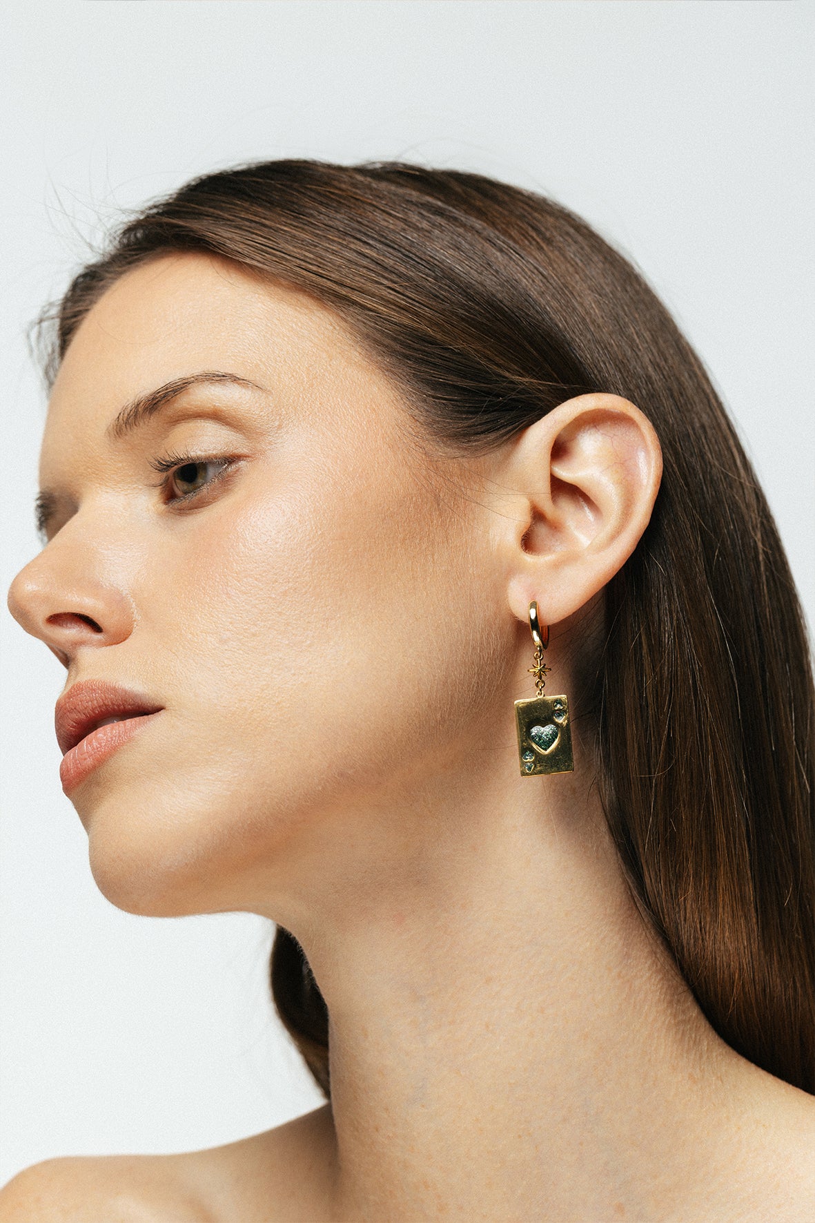 femme portant boucle d'oreille as de coeur email vert