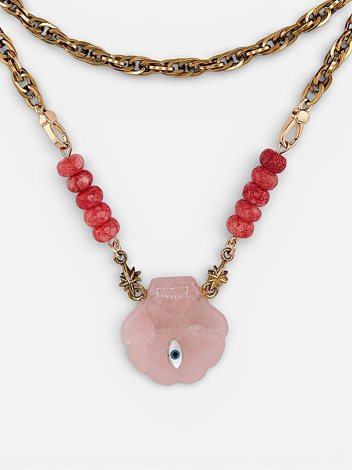 Gros plan pendentif coquillage quartz rose et œil nacre Bingo Club
